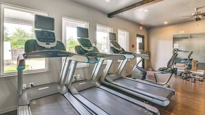 A gym with treadmills, exercise bikes, and weights.