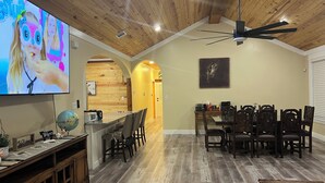 A dining area with a wooden ceiling and a TV displaying animated characters. - Home in Fort Worth (Fort Worth)