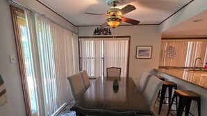 A dining area with a large table, chairs, a ceiling fan, and a patterned rug. - Winding Hollow : Spacious 5-bedroom house in tranquil Arlington (Arlington)