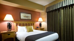A hotel room with a large bed, two bedside tables with lamps, a headboard, a framed picture on the wall, and a window with curtains. - Worldmark Steamboat Springs/2 Bedroom Deluxe Condo (Steamboat Springs)