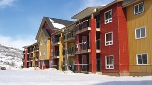 A multi-story hotel with balconies and a snowy landscape in the background. - Worldmark Steamboat Springs/2 Bedroom Deluxe Condo (Steamboat Springs)
