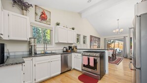 A modern kitchen with white cabinets, stainless steel appliances, and a red rug. - 2-beds, 3 baths, 1 office, full kitchen townhome in beautiful Boulder, heat & AC (Boulder)