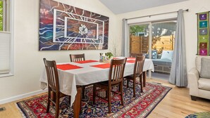 A dining area with a table set for four, a large abstract painting above the table, and a view of the outdoors through a sliding glass door. - 2-beds, 3 baths, 1 office, full kitchen townhome in beautiful Boulder, heat & AC (Boulder)