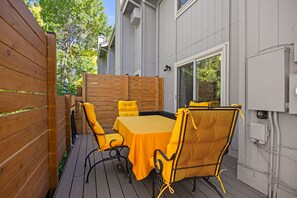An outdoor patio with a table and chairs, wooden fence, and a building in the background. - 2-beds, 3 baths, 1 office, full kitchen townhome in beautiful Boulder, heat & AC (Boulder)