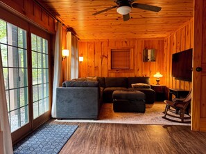 TV connectée, cheminée, table de tennis de table, livres