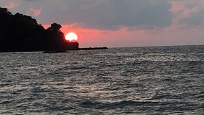 A sunset over a body of water with a rocky coastline. -  Surrounded by beautiful views + 7 min. walk to the beach (Lo de Marcos)