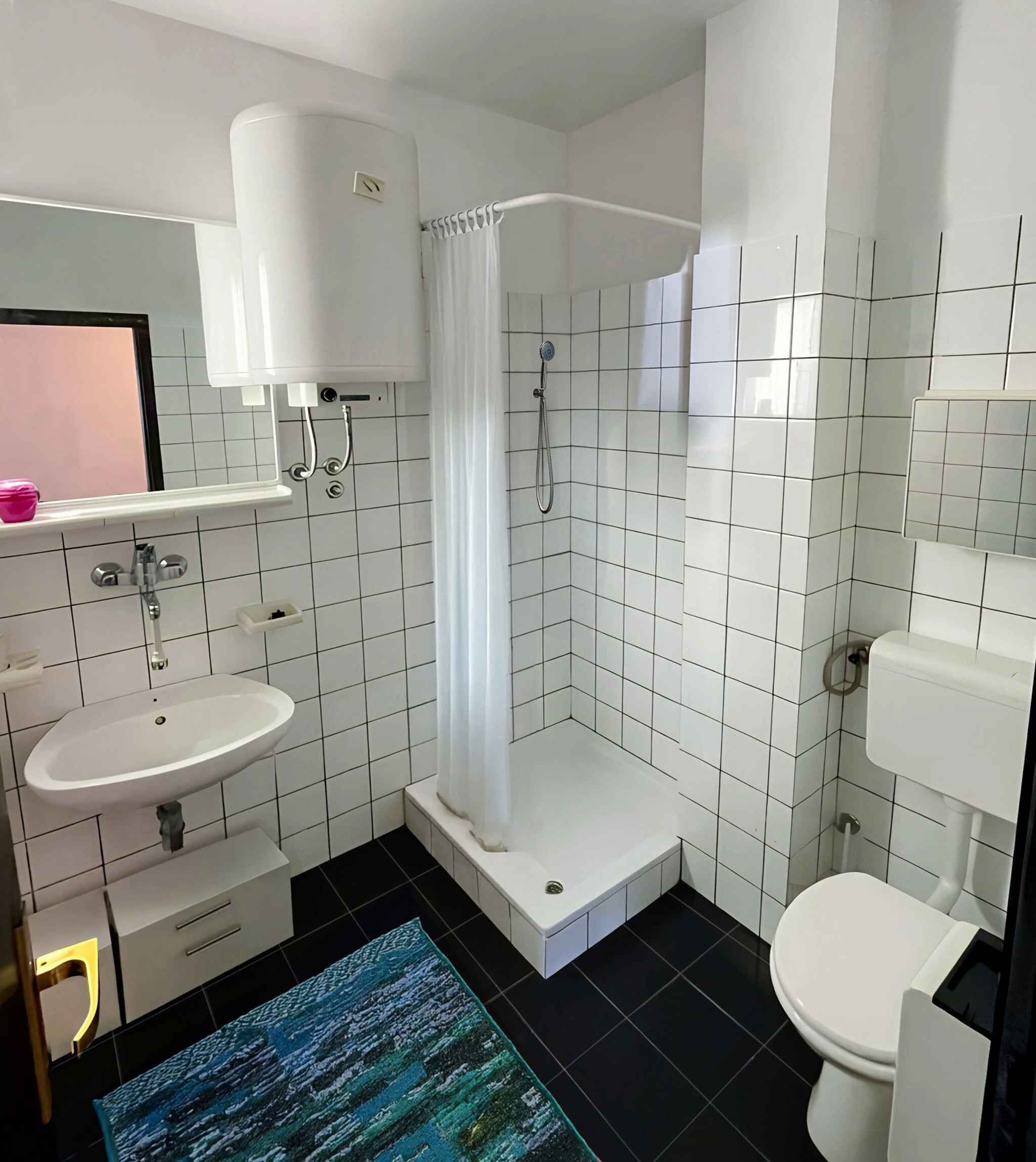 Un baño moderno con lavabo, inodoro, ducha y espejo.