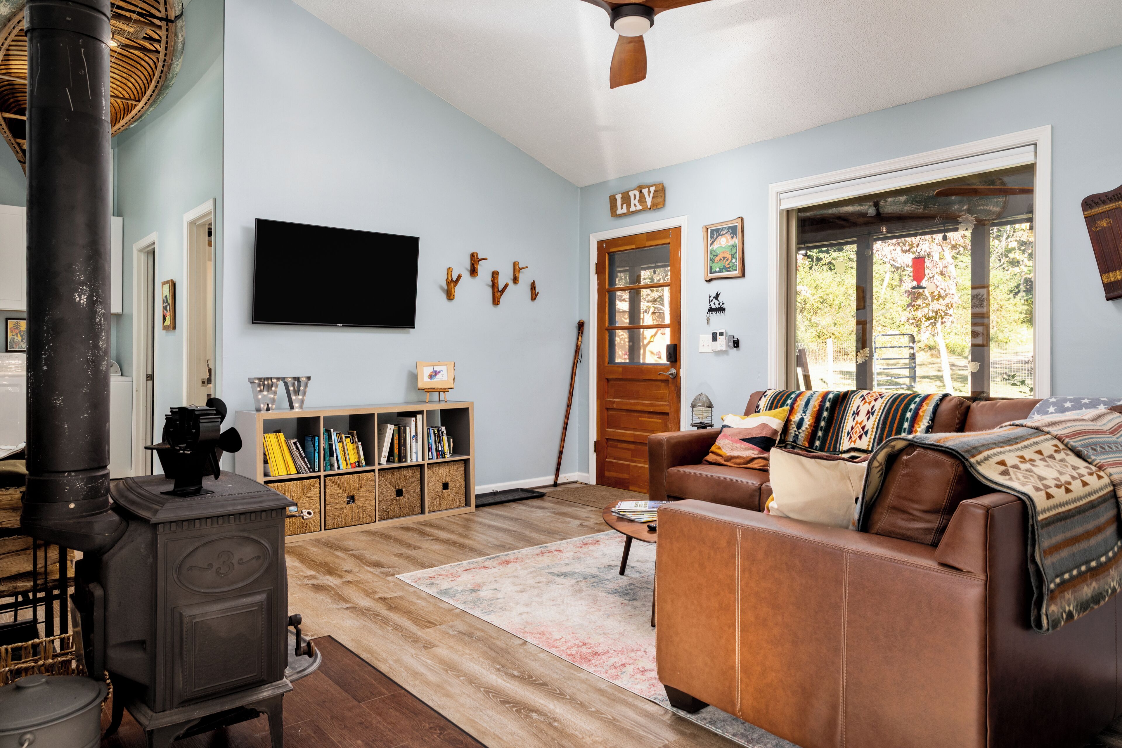 A living room with a fireplace, a sofa, a television, and a bookshelf.