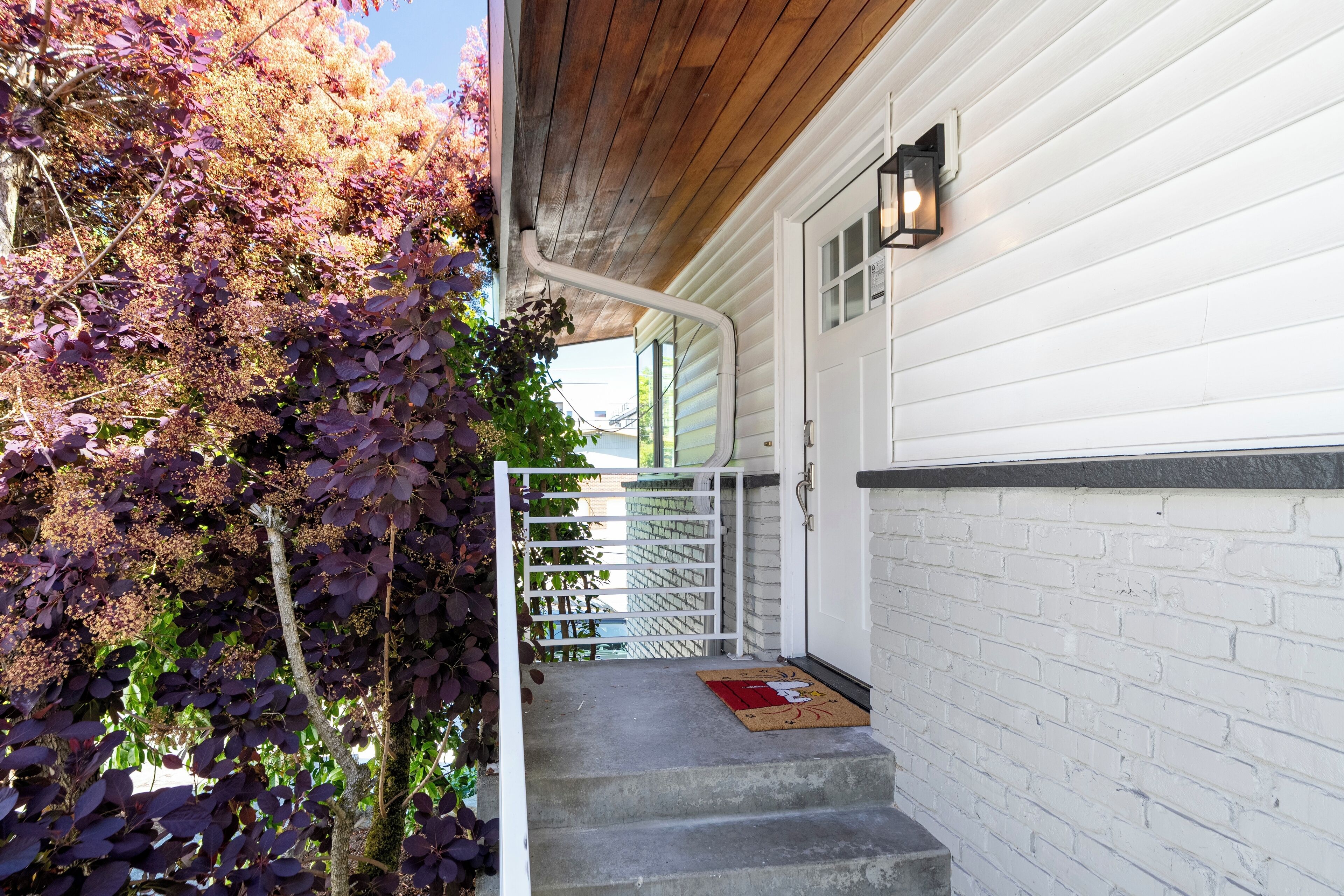 A wooden staircase with a white door and a brick wall.