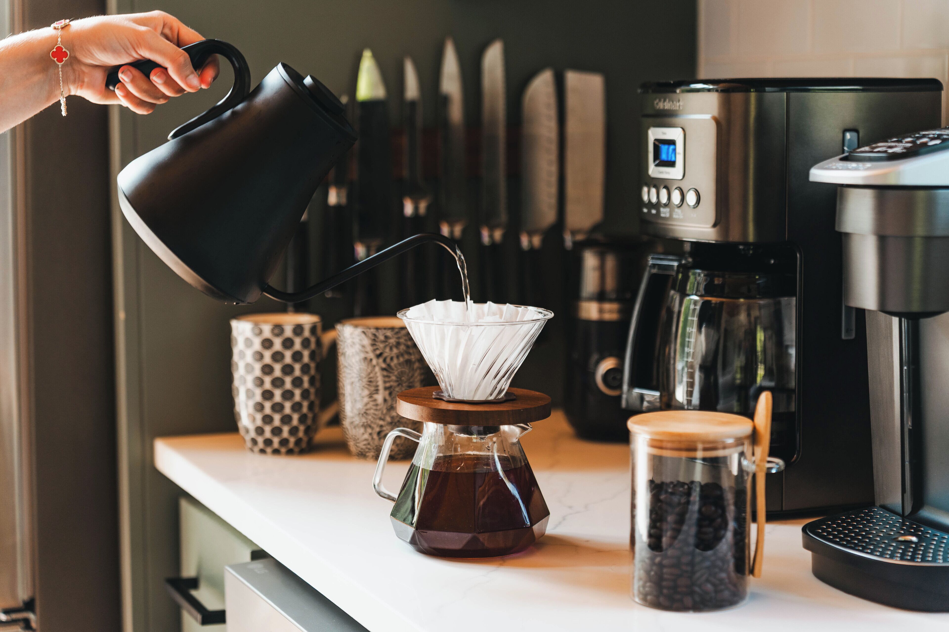 Eine Kaffeemaschine auf einer Küchenarbeitsplatte mit Kaffeekanne und Filter.