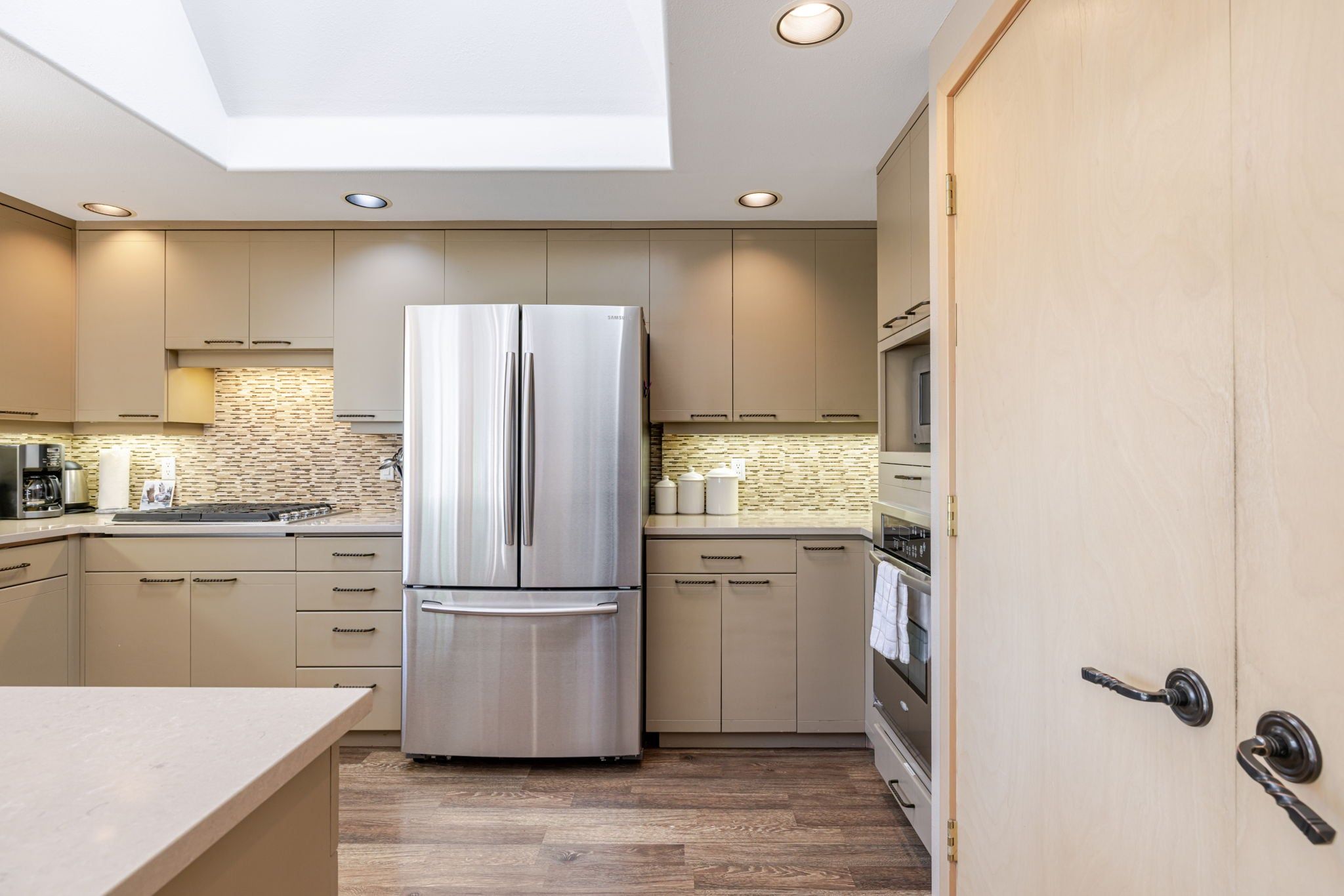 A modern kitchen with a built-in refrigerator, oven, and microwave.