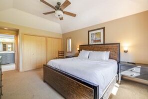 Ein Schlafzimmer mit Bett, Nachttisch, Sessel, Kleiderschrank und Deckenventilator.