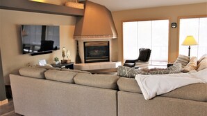 A living room with a sofa, a fireplace, a television, and a lamp. - Lone Eagle Landing 2 - Updated, A/C, Hot Tub, SHARC Passes (Sunriver)