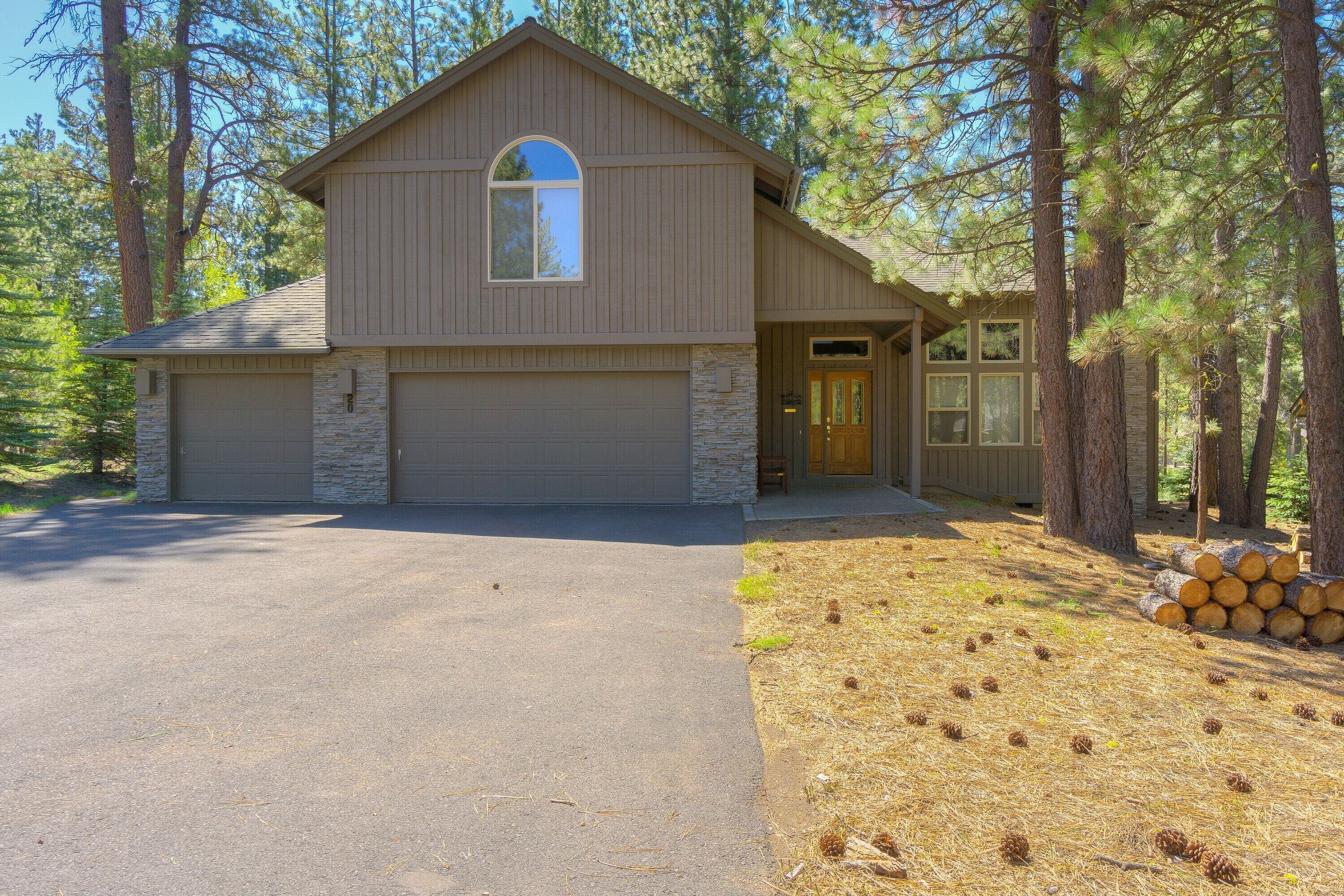 A two-story house with a stone foundation, a garage, and a front door with a glass panel.