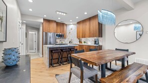 A modern kitchen with wooden cabinets, stainless steel appliances, and a marble island. - Walk to Slopes Hot Tub + Balcony + Views Mins to Main Street Deer Valley Haven by Avantstay (Park City)