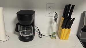 A kitchen counter with a coffee maker, a bottle of hand soap, and a knife block. - 1 BHK private basement suite (Regina)