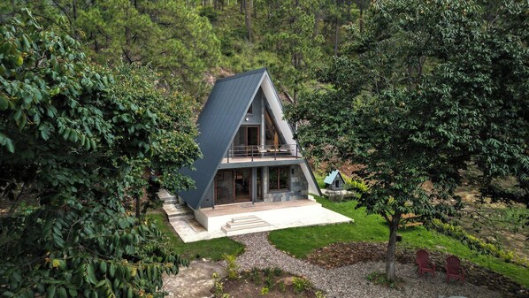 A modern house with a sloped roof, large windows, and a balcony.