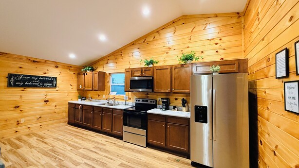Una cocina con paredes de madera, electrodomésticos de acero inoxidable y un letrero de pizarra.