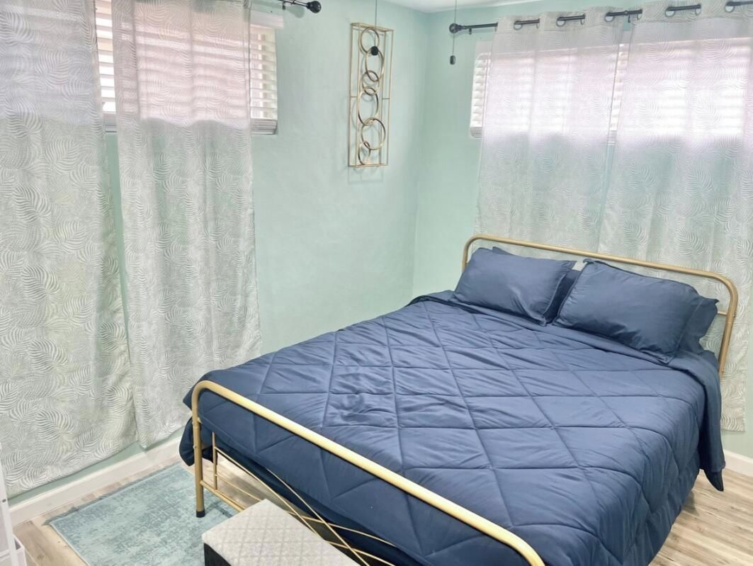 Ein Schlafzimmer mit Bett, Vorhängen und einer Wanddekoration.