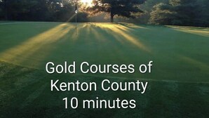 A golf course with a flagstick in the center, surrounded by trees and sunlight. - Sunset Family Point (Independence)