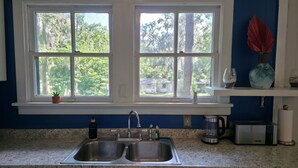 A kitchen with a double sink, a coffee maker, and a dish rack. - Duck Pond Getaway (Gainesville)