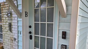 A light blue door with a glass panel, a welcome sign, and a mailbox. - Duck Pond Getaway (Gainesville)