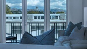 A modern hotel room with a large window offering a view of a building with a dome and mountains in the background. - Deluxe 1BR 1BA Stunning Amenities-Pool, Htub, Gym+ (Salt Lake City)