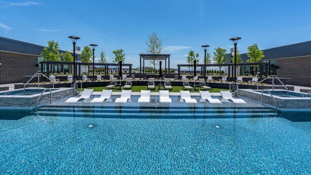 A modern outdoor pool area with lounge chairs, a covered seating area, and a clear blue sky. - Deluxe 1BR 1BA Stunning Amenities-Pool, Htub, Gym+ (Salt Lake City)