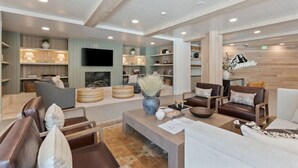 A spacious lounge area with leather sofas, wooden coffee tables, and a fireplace. - Deluxe 1BR 1BA Stunning Amenities-Pool, Htub, Gym+ (Salt Lake City)