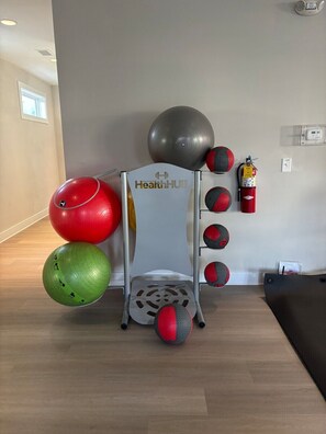 Ein Fitnessbereich mit Übungsbällen und Trainingsgeräten von HealthHub.