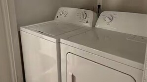 A laundry room with two white front-loading washing machines.