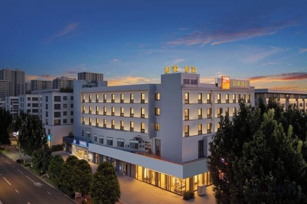 A multi-story hotel with a modern design, featuring a prominent entrance and a rooftop terrace. - Home Inn (Zhaoyuan Fuqian Square Zhenhua) (Zhaoyuan)