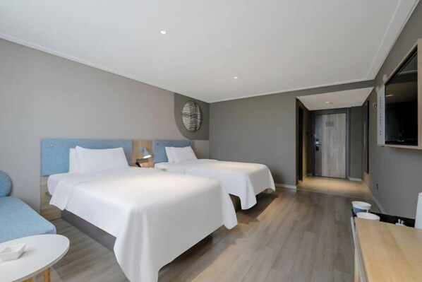 A hotel room with two beds, a small seating area, a TV, and a door leading to a hallway. - Home Inn (Zhaoyuan Fuqian Square Zhenhua) (Zhaoyuan)