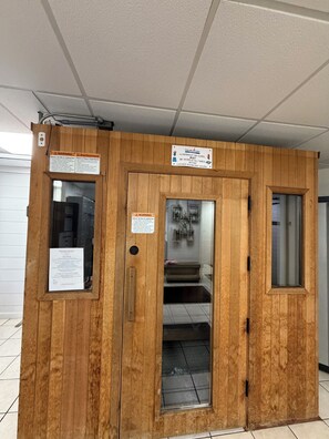 Una habitación de madera con una ventana, una puerta y un cartel con indicaciones.