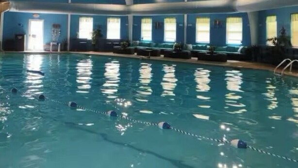 An indoor swimming pool with a high ceiling and large windows. - Upscale Mountain Cottage with Hot Tub & Fireplace (Long Pond)