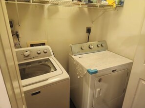 Una sala de lavandería con lavadora y horno.