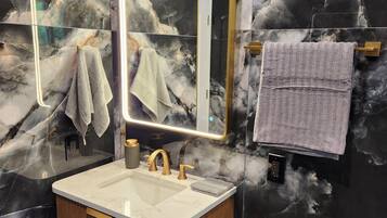 Een haardroger, handdoeken, zeep, toiletpapier