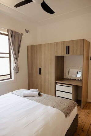 Un dormitorio con cama, armario y espejo.