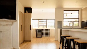A modern kitchen with wooden flooring, a built-in oven, and a window overlooking a balcony. - Pet Friendly 3 Bed Home w Workspace & Creek Views (Tighes Hill)