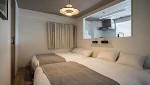 A hotel room with two beds, a ceiling light, a window with curtains, a mirror, and a small shelf with a clock. - LIT Hiroshima Ekimae (Hiroshima)