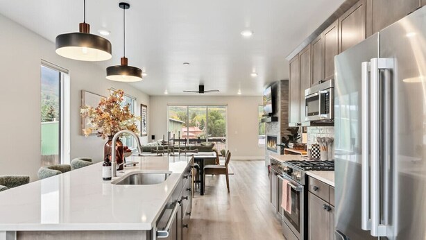 A modern kitchen with a central island, stainless steel appliances, and pendant lighting. - 1301 Adams Ave - Silverthorne (Silverthorne)