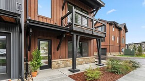 A modern building with a wooden facade, a balcony, and a stone base. - 1301 Adams Ave - Silverthorne (Silverthorne)
