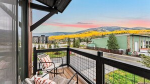A balcony with wicker chairs and a view of a mountain range and yellow fields. - 1301 Adams Ave - Silverthorne (Silverthorne)