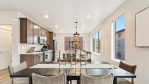A modern kitchen with dark wood cabinets, stainless steel appliances, and a central island. - 1301 Adams Ave - Silverthorne (Silverthorne)