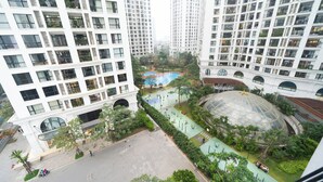 Un edificio residencial alto con varios balcones, un patio central con piscina y una estructura en forma de cúpula.