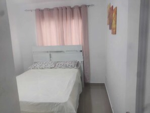 Cortinas opacas y tabla de planchar con plancha