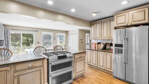 A spacious kitchen with wooden cabinets, a stainless steel refrigerator, and a double oven. - SAUNA IS TEMPORARILY OUT OF SERVICE . (Norwich)