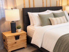 Een slaapkamer met een bed, nachtkastjes en een nachtkastje.