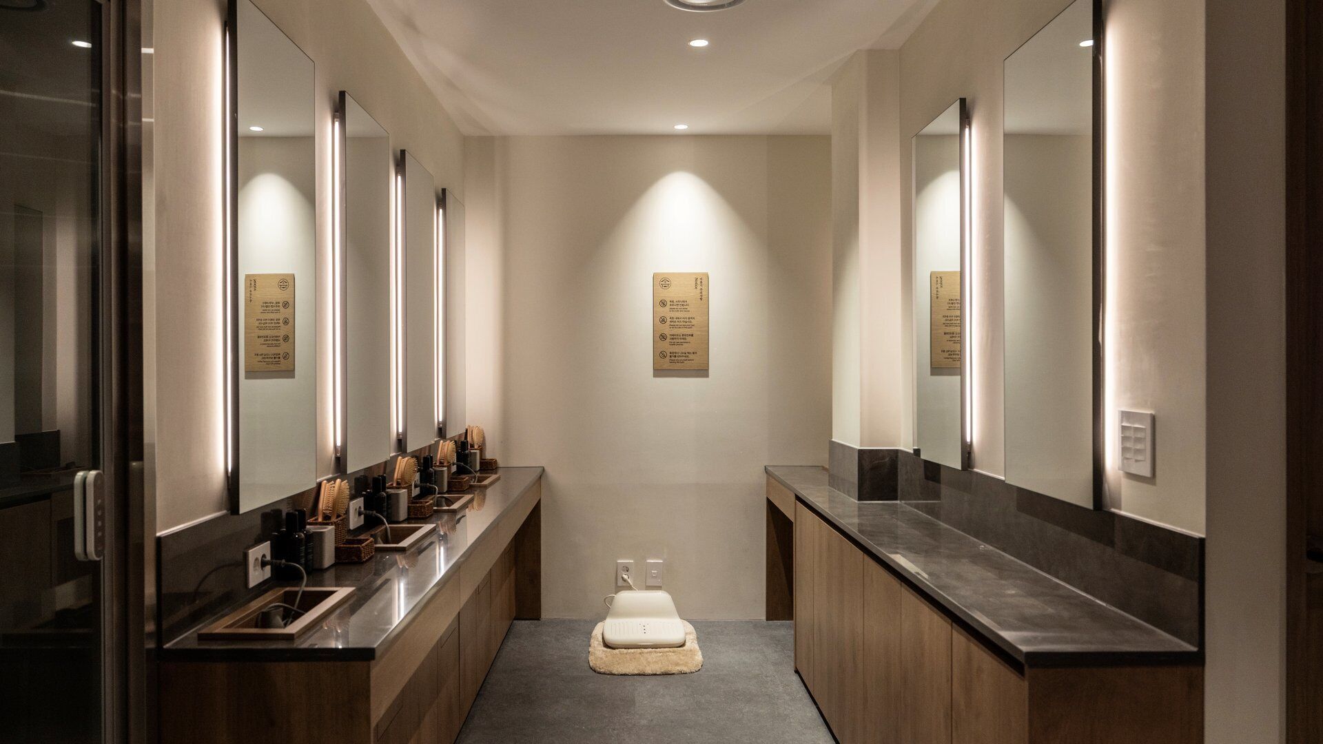 Un baño moderno con varios lavamanos, espejos y un inodoro central.