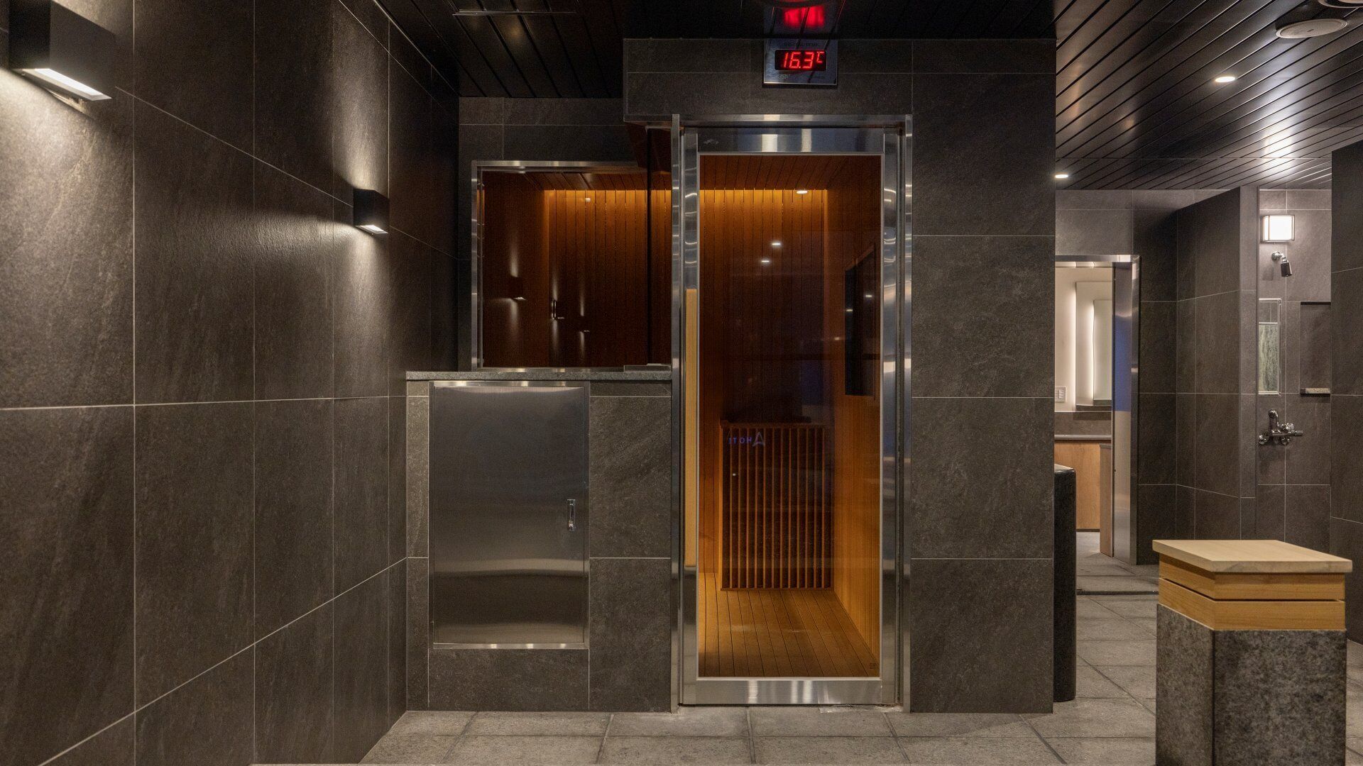 A modern elevator with a digital display, a wooden interior, and a metallic exterior.
